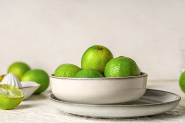 Taze limonlu kase ve beyaz arka planda meyve sıkacağı.