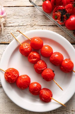 Beyaz ahşap arka planda lezzetli ızgara domatesli fırın tabağı ve tabak.