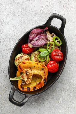 Gri arka planda ızgara sebzeli fırın.