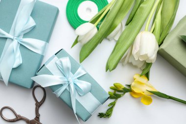 Hediye kutuları ve beyaz arka planda güzel laleler. Uluslararası Kadınlar Günü