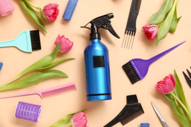 Bej arka planda güzel pembe laleleri olan kuaför aletleri.