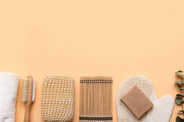 Masaj eldivenli kompozisyon, bambu paspas ve bej arka planda banyo süngeri.