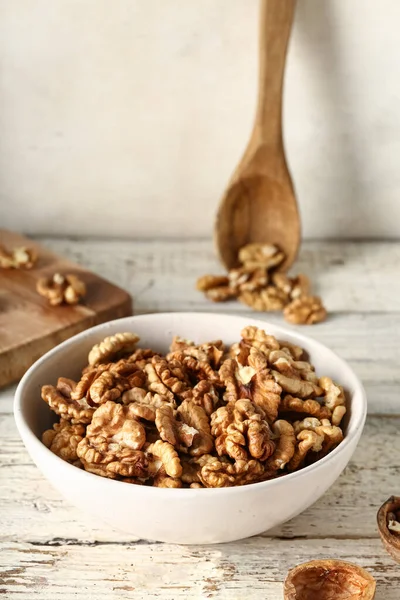 Masanın üzerinde beyaz duvara karşı bir kase lezzetli ceviz