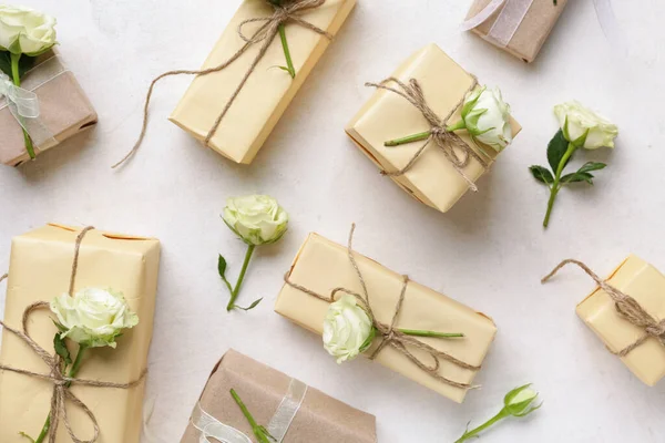 Beyaz arka planda güzel güller olan bir sürü hediye kutusu. Uluslararası Kadınlar Günü