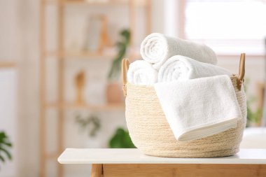 Tuvaletteki masanın üzerinde temiz yumuşak rulo havlular olan sepet.