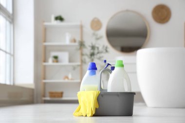 Bir kova dolusu deterjan ve banyoda yerde lastik eldiven.