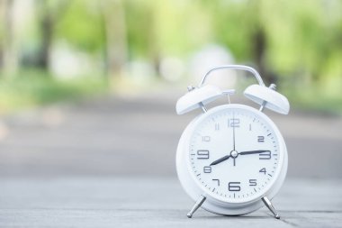 Parkın dışındaki kaldırımda beyaz alarmlı saat