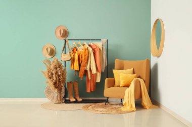 Askısı, koltuğu ve otları olan bir giyim mağazası.