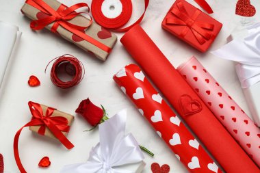 Hediye kutusu, ambalaj kağıdı ve kalpler beyaz masada. Sevgililer Günü kutlaması