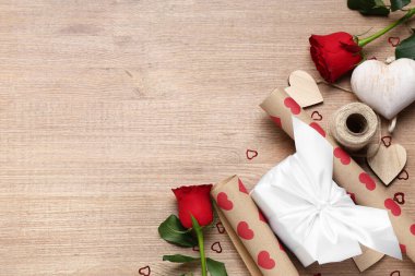Hediye kutulu kompozisyon, ambalaj kağıdı, gül çiçekleri ve ahşap arka planda dekor. Sevgililer Günü kutlaması