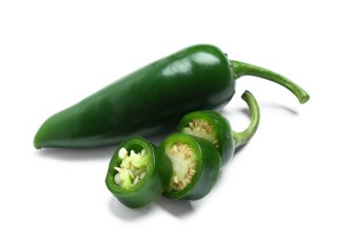 Beyaz arkaplanda yeşil biberler var.