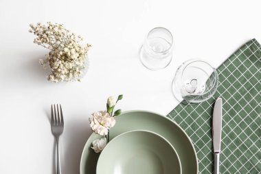 Beyaz arkaplanda çiçekler olan güzel masa ayarları