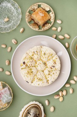 Fıstıklı ve yeşil arka planda baklavalı Tahini halkası.