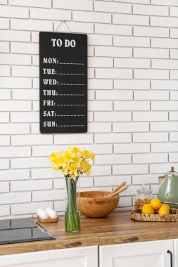 Mutfak tezgahında çiçek açan vazo.