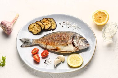 Beyaz arka planda lezzetli ızgara dorado balığı tabağı.