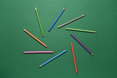 Yeşil karatahta üzerinde renkli kalemler grubu