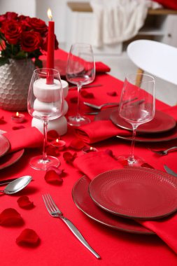 Sevgililer Günü için hazırlanmış şölen masası kırmızı güller ve evde yanan mumlarla süslenmiş.