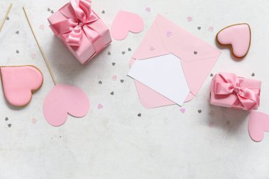 Kalp şeklinde tatlı kurabiyeler ve beyaz arka planda zarf olan hediye kutuları. Sevgililer Günü kutlaması