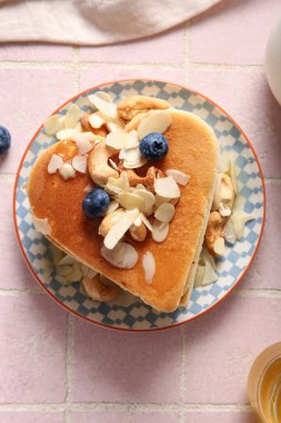 Kalp şeklinde lezzetli gözleme tabağı, pembe fayanslı yaban mersini ve fındık. Sevgililer Günü kutlaması