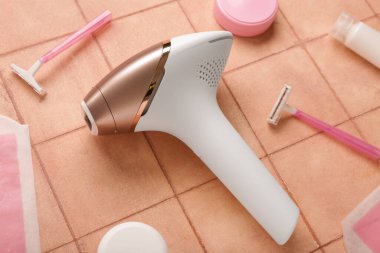 Balmumu şeritleri, jiletleri ve pembe fayanslı kozmetik ürünleriyle modern fotoepilatör.