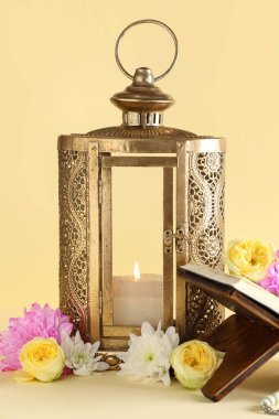 Çiçekli Müslüman lamba ve açık sarı arka planda Kuran. Ramazan kutlaması