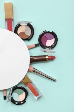 Açık mavi arkaplanda farklı makyaj ürünleri olan boş kart
