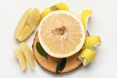 Tahta tahta tahta tahta, yarım taze meyve ve beyaz arka planda yapraklar.