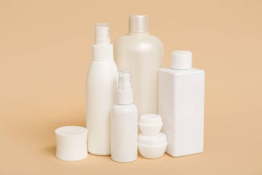 Bej arka planda kavanoz ve kozmetik ürünleri içeren kompozisyon