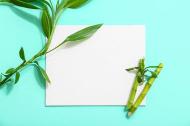 Turkuaz arka planda yeşil bambu saplı boş kart