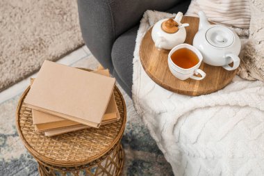 Çaydanlık ve çay. Kitaplar odada, kanepe manzaralı.