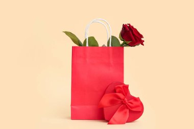 Güzel kırmızı gül ve sarı arka planda hediye paketi. Sevgililer Günü kutlaması
