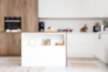 Ada masası ve beyaz tezgahlı şık mutfak manzarası bulanık