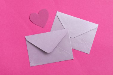 Zarflar ve mor arka planda kağıt kalp. Sevgililer Günü kutlaması