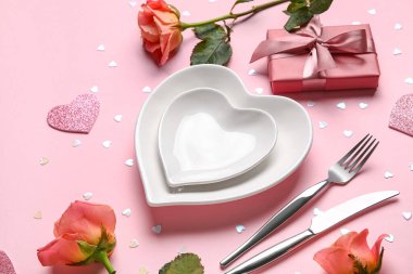 Hediye kutusu ve pembe arka planda güzel güller olan şık bir masa. Sevgililer Günü kutlaması