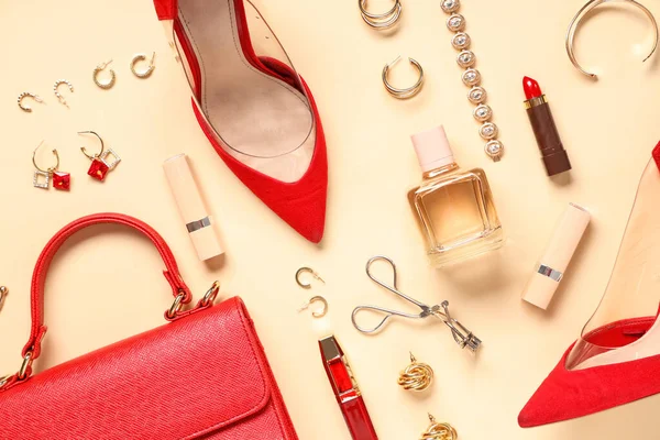 Bej arka planda kırmızı deri çanta, mücevher ve ruj güzel kompozisyonu