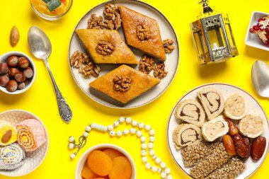 Geleneksel Ramazan tatlıları, tasbih ve fanoos sarı arka planda