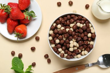 Çilekli tabak ve bej arka planda çikolatalı mısır topları, yakın plan.