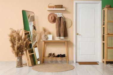 Koridorun içinde askı, ayna ve kapı var.