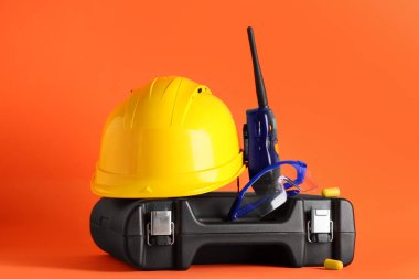 Turuncu arka planda sabit şapka, alet kutusu ve radyo vericisi