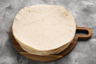 Gri arka planda taze ince lavları olan ahşap tahta tahta, yakın plan.