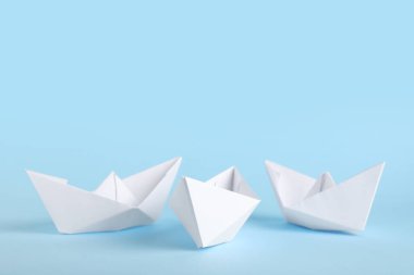 Mavi arka planda beyaz kağıt tekneler