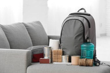 Odadaki kanepede acil durum çantası ve gerekli şeyler.