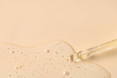 Bej arka planda kozmetik yağlı bir boru.