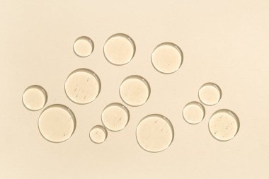 Bej arka planda kozmetik yağı damlaları