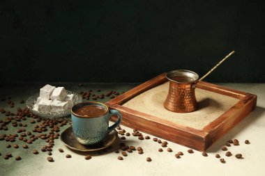 Bir fincan sıcak kahve ve arkaplanda Türk zevki olan bir tabak