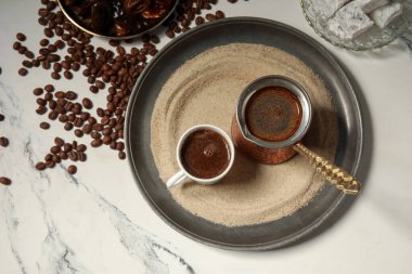 Bir fincan sıcak Türk kahvesi ve kum üzerinde beyaz arka plan