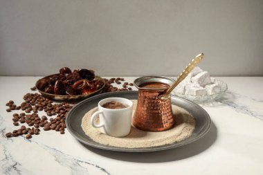 Bir fincan sıcak Türk kahvesi ve kum üzerinde beyaz arka plan