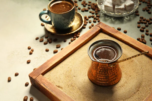 Kum üzerinde sıcak Türk kahvesi ve grunge arka planda fasulye.