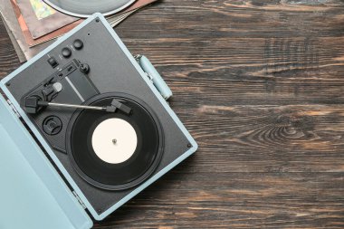 Koyu ahşap arka planda vinil diski olan kayıt çalar