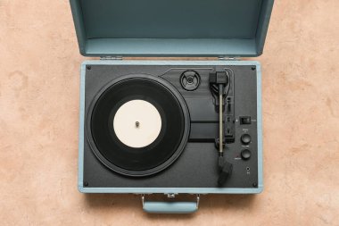 Bej arka planda vinil diski olan kayıt oynatıcı
